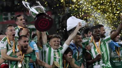 Los jugadores del Betis celebran con el trofeo de campeones de la Copa del Rey tras ganar al Valencia en la final.