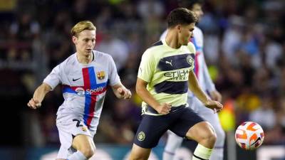 El delantero argentino del Manchester City, Julián Álvarez , cubre el balón ante Frenkie de Jong, del FC Barcelona.