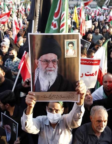 Los manifestantes progubernamentales iraníes sostienen fotografías del líder supremo, el ayatolá Ali Khamenei, durante una manifestación contra las recientes protestas.