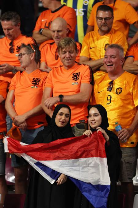 Dos aficionadas árabes entre los neerlandeses con una bandera de Países Bajos.