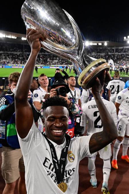 Vinicius, muy sonriente, alzando el trofeo de campeón de la Supercopa de Europa.