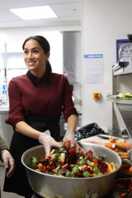 Mientras que Kate visitaba la Universidad College London, Meghan se metía en la cocina para ayudar a preparar 200 platos de comida.