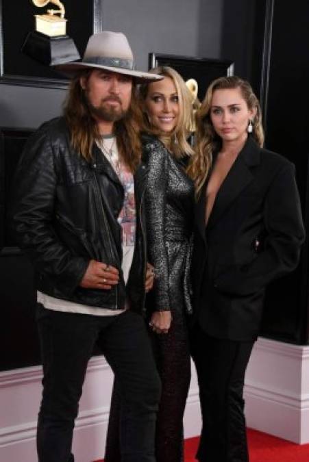 Miley Cyrus dejó a su esposo Liam Hemsworth en casa y desfiló por la alfombra roja acompañada de sus padre, Billy Ray Cyrus y su madre Tish.