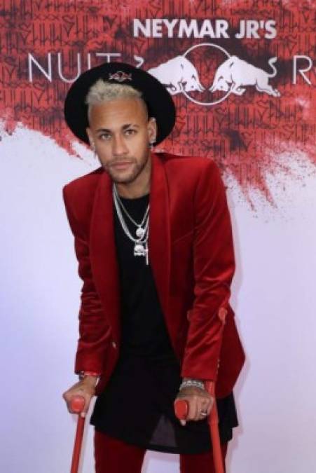 La estrella brasileña Neymar llegó a la fiesta apoyándose en unas muletas de color rojo vivo, a conjunto con el 'dress code' de la velada.