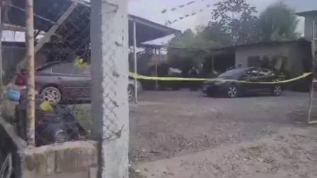 Agentes de la Policía cerraron el negocio de lavar carro mientras llega personal forense a levantar el cadáver.