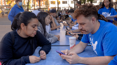 Migrantes recién llegados se reúnen con voluntarios en un centro de bienvenida en el Lower East Side.