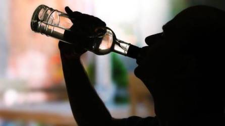 Imagen que muestra la silueta de un hombre bebiendo alcohol.