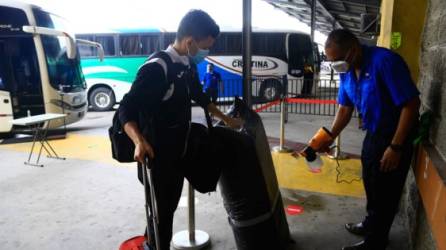 Las maletas de los usuarios del transporte interurbano son sanitizadas antes de abordar las unidades. Foto: LA PRENSA