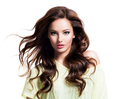 Face of the sensuality beautiful woman with long brown curly hair in yellow shirt