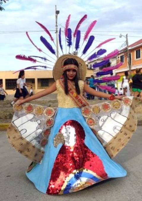 Una estudiante modela el delicado traje que le fue confeccionado. Destacan las catedrales, los granos básicos de nuestra alimentación y una guacamaya roja, ave nacional de Honduras.