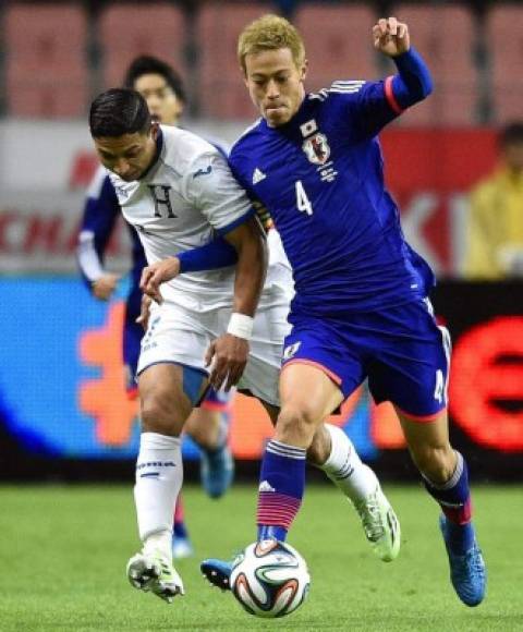 El jugador de la selección japonesa de fútbol, Keisuke Honda, lucha por el balón con el hondureño Emilio Izaguirre.