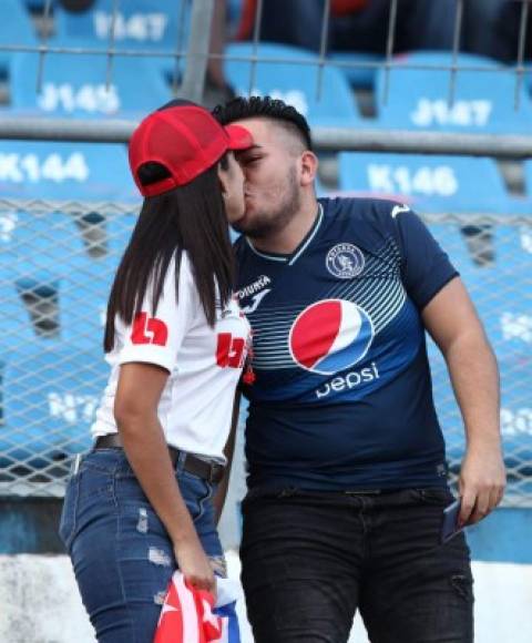 Divididos por 90 minutos. Esta pareja de aficionados en el clásico Olimpia-Motagua.