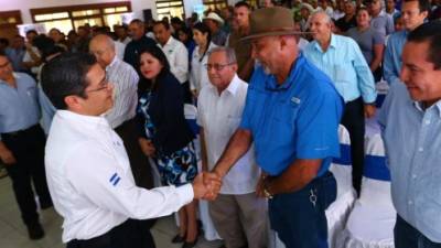 El presidente Juan Orlando Hernández estrecha la mano de Leopoldo Durán, dirigente de la Federación Nacional de Agricultores y Ganaderos de Honduras (Fenagh).