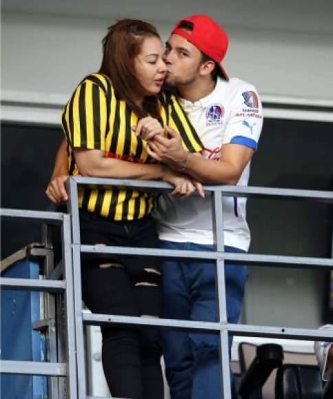 Novios y rivales. Una pareja apoyando a sus equipos en las gradas.