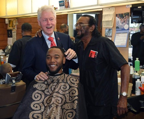 LAS VEGAS, NV - NOVEMBER 03: (L-R) Former U.S. President Bill Clinton jokes around as he pretends to cut D.J. Anderson's hair as Hair Unlimited owner Mack Smith Jr. looks on at his barbershop on November 3, 2016 in Las Vegas, Nevada. Clinton is urging people to vote for his wife, Democratic presidential nominee Hillary Clinton, and Nevada democratic candidates during early voting, which ends on November 4 in the battleground state, and on Election Day. Ethan Miller/Getty Images/AFP
