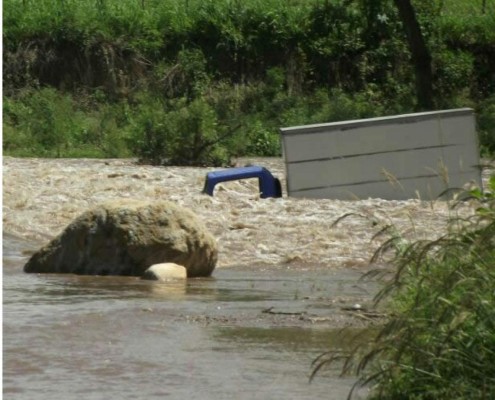 Camión es arrastrado por río y sus ocupantes se salvan de morir