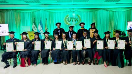 Graduados de la UTH muestran orgullosos sus títulos.
