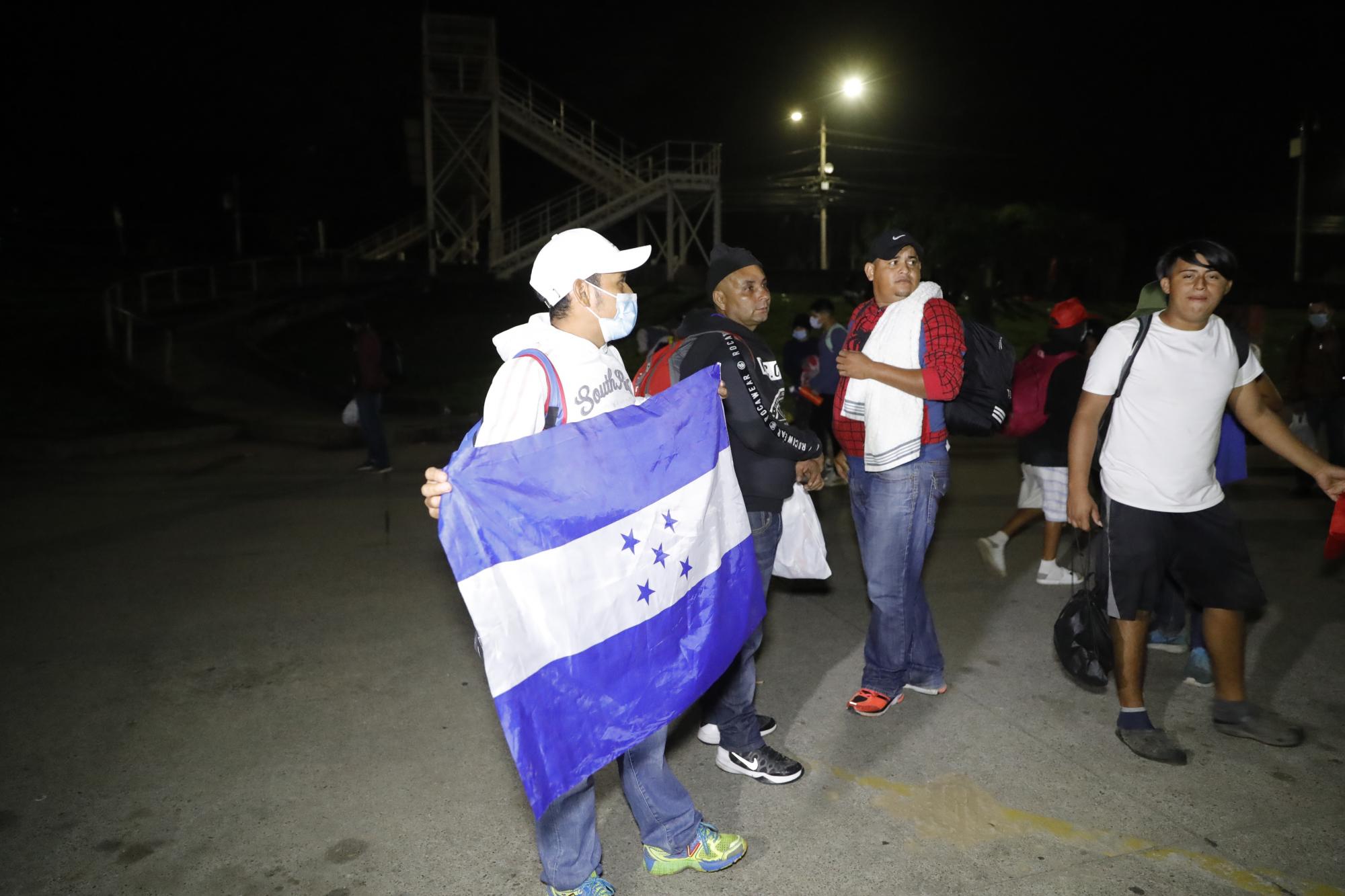 Un grupo de migrantes hondureño caminan en una caravana rumbo a Estados Unidos, en la madrugada de hoy, en la Gran Central Metropolitana de San Pedro Sula (Honduras) en enero de 2022.