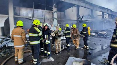 Los bomberos intentan rescatar a las personas atrapadas bajo los escombros de un edificio impactado por un misil en Ucrania.