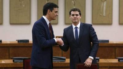 Los líderes del PSOE, Pedro Sánchez (izq.) y de Ciudadano, Albert Rivera, sellan su acuerdo con un apretón de manos.