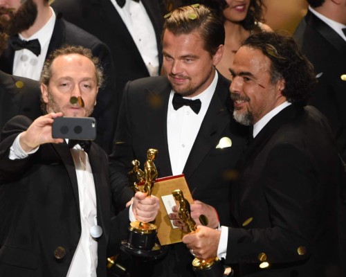 (L to R) Cinematographer Emmanuel Lubezki , Actor Leonardo DiCaprio and Director Alejandro Gonzalez Inarritu pose for a selfie with their awards on stage at the 88th Oscars on February 28, 2016 in Hollywood, California. AFP PHOTO / MARK RALSTON / AFP / MARK RALSTON