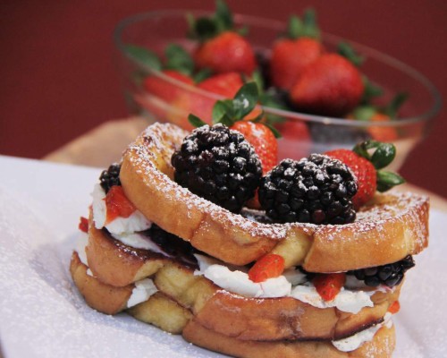 Acompañe las tostadas francesas con frutas y queso crema.