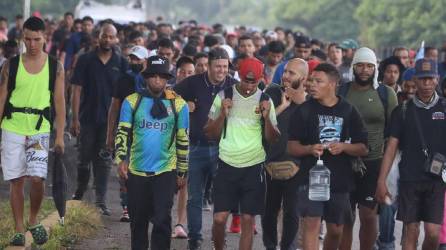 Migrantes centroamericanos caminan en caravana.