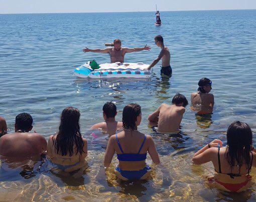 El sacerdote ofreció una misa para un grupo de jóvenes en el mar Mediterráneo por la ola de calor.