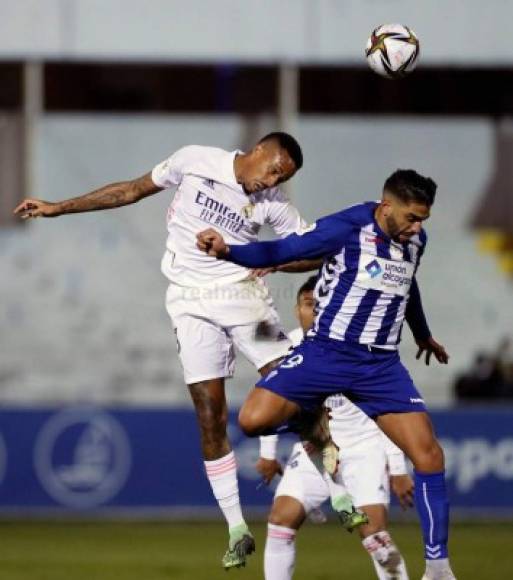 El hondureño Jona Mejía, titular con el Alcoyano, saltando por el balón con Eder Militao del Real Madrid.