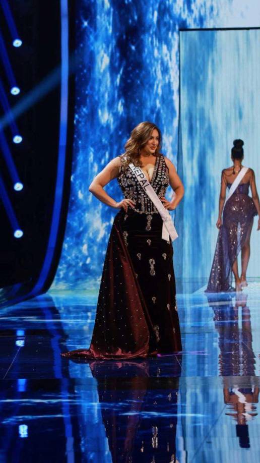 La admiración y apoyo hacia la representante de Nepal se pondría de manifiesto también en su desfile en traje noche, donde lució un vestido de terciopelo color vino adornado con pedrería.