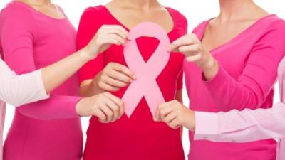 healthcare, people and medicine concept - close up of women in blank shirts with pink breast cancer awareness ribbon over white background