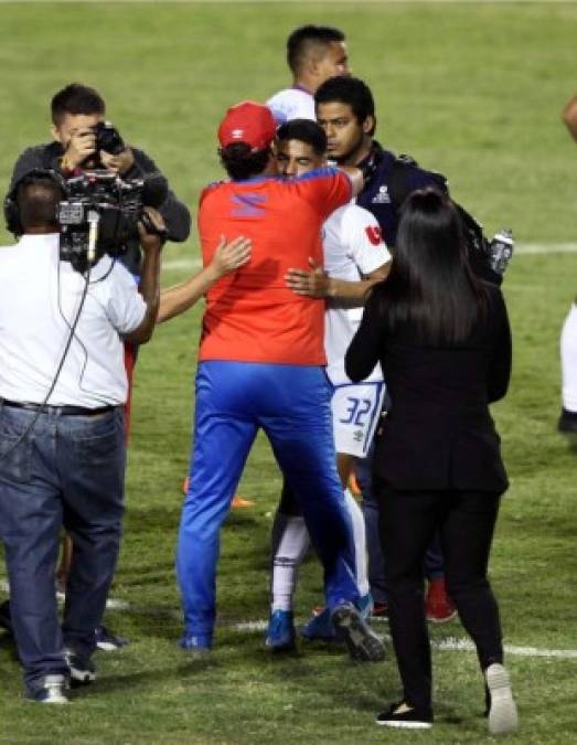Pedro Troglio abrazando al joven volante Carlos Pineda en el centro del campo.