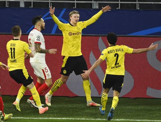 Dortmund's Norwegian forward Erling Braut Haaland (C) celebrates scoring the 2-0 goal with his teammates from the penalty spot on his second attempt during the UEFA Champions League, Last-16 2nd-Leg football match BVB Borussia Dortmund v Sevilla FC at the Signal Iduna stadium in Dortmund, western Germany on March 9, 2021. (Photo by Ina Fassbender / various sources / AFP)
