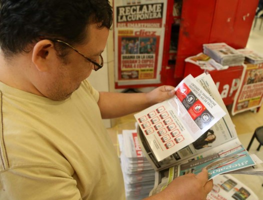 Un lector de LA PRENSA lee las instrucciones de la cuponera para la promoción.