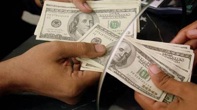 Hondureños cambian dólares en una entidad bancaria.