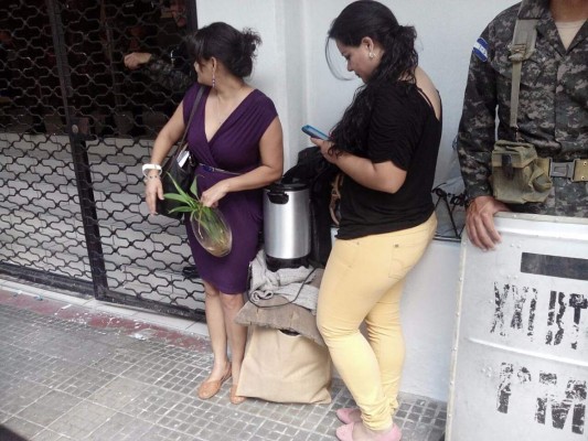 Dos empleadas de la DEI con sus pertenencias al aire libre después de ser despedidas por el Gobierno.