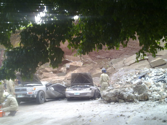 Cae muro perimetral sobre una veintena de autos