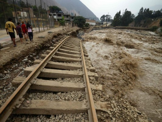 TOPSHOT - View of sections of the central railroad track that follows the Rimac River, which suffered severe damage by rising water and flash foods in the town of Chosica, at the foot of the Andes mountains east of Lima, on March 18, 2017. The El Nino climate phenomenon is causing muddy rivers to overflow along the entire Peruvian coast, isolating communities and neighbourhoods. Thousands have been affected since January, and 72 people have died. Most cities face water shortages as water lines have been compromised by mud and debris. / AFP PHOTO / CRIS BOURONCLE