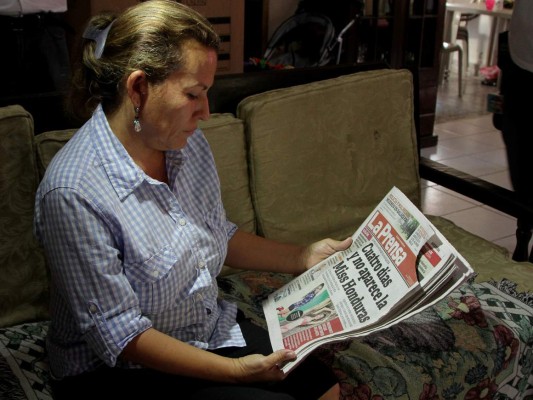 Teresa Muñoz observa la publicación de Diario La Prensa donde se destaca la desaparición de sus hijas.