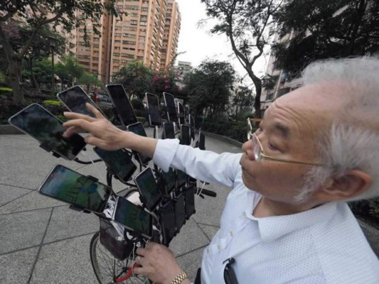Chen San-yuan, un maestro de Feng Shui de 70 años, usa 22 teléfonos celulares montados en su bicicleta junto con dos teléfonos móviles de mano para capturar Pokémon en la ciudad de Nueva Taipei, Taiwán. EFE