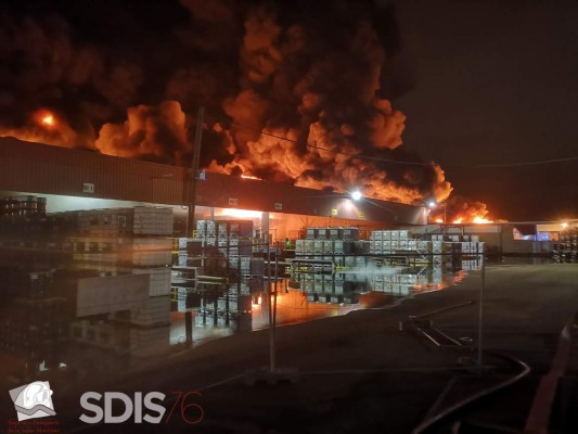 This handout photograph released by Service Departemental d'incendie et des sec (SDIS) on September 27, 2019, shows firefighters at the scene of a blaze at a Lubrizol factory in Rouen, north-western France early September 26, 2019. - Firefighters have extinguished a huge blaze that broke out at a chemical factory in northern France and forced authorities to close schools and warn of pollution risks for the Seine river, local authorities said on September 27, 2019. The fire erupted early morning at a storage facility near the city of Rouen owned by Lubrizol, a manufacturer of industrial lubricants and fuel additives which is owned by the billionaire American investor Warren Buffett. (Photo by YACINE MOUFADDAL / SDIS / AFP) / RESTRICTED TO EDITORIAL USE - MANDATORY CREDIT 'AFP PHOTO / SDIS/YACINE MOUFADDAL' - NO MARKETING - NO ADVERTISING CAMPAIGNS - DISTRIBUTED AS A SERVICE TO CLIENTS