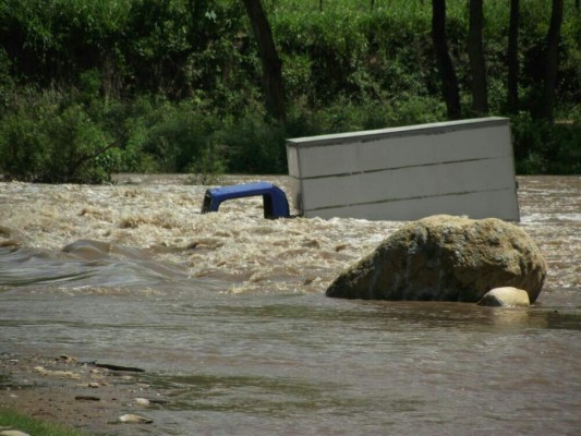 Camión es arrastrado por río y sus ocupantes se salvan de morir