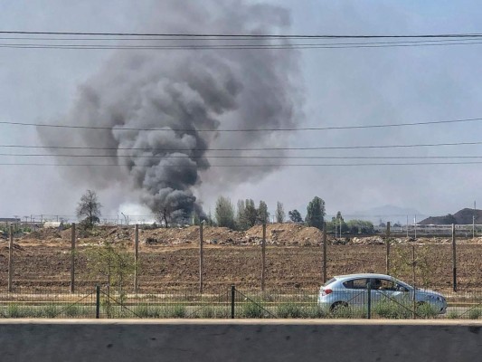 Smoke billows from a warehouse in Renca neighbourhood, Santiago, on October 20, 2019. - According to Chilean authorities five people died after the warehouse was set on fire during mass protests triggered by the governments attempt to hike the subway fee. Fresh clashes broke out in Chile's capital Santiago on Sunday after two people died when a supermarket was torched overnight in the third day of violent protests. (Photo by PEDRO UGARTE / AFP)