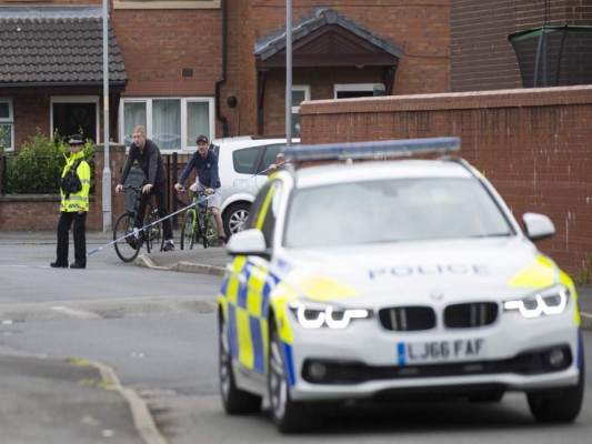 Police carry out an operation in a street in the Moss Side area of Manchester on May 28, 2017.A British minister said Sunday members of suicide bomber Salman Abedi's network could still be a large, as thousands defied the terror threat to take part in an annual half marathon. As runners pounded the streets of the northwestern English city, police arrested a 25-year-old man in the eastern Old Trafford area, bringing the number now detained on UK soil in connection with the attack to 12. / AFP PHOTO / JOHN SUPER