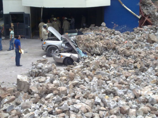 Cae muro perimetral sobre una veintena de autos