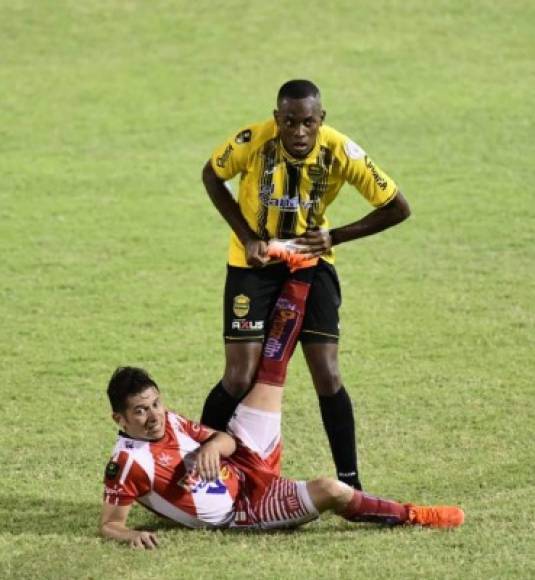 Jamal Charles le ayuda a Jairo Puerto a estirar la pierna izquierda.