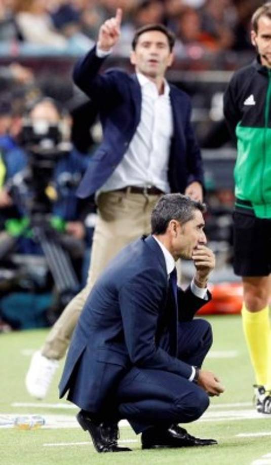Ernesto Valverde, agachado, observando el partido y Marcelino dando indicaciones a sus jugadores.