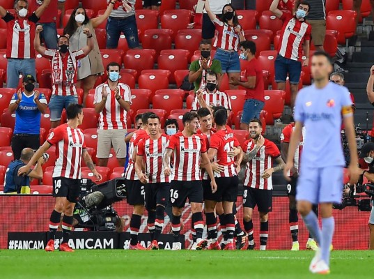 Athletic Bilbao's Spanish defender Inigo Martinez (R) celebrates with teammates after scoring the opening goal during the Spanish League football match between Athletic Club Bilbao and FC Barcelona at the San Mames stadium in Bilbao on August 21, 2021. (Photo by ANDER GILLENEA / AFP)