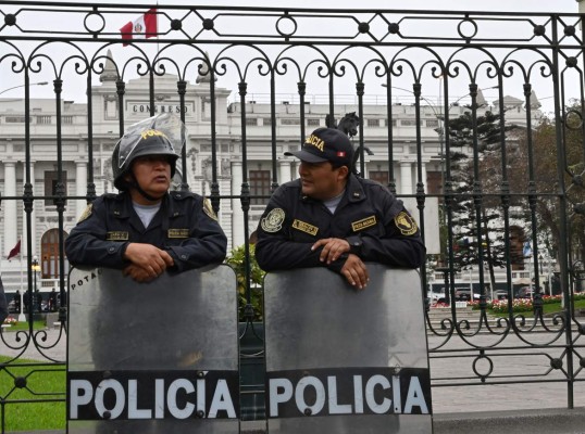 Police officers stand guard at the Peruvian Congress building in Lima on September 30, 2019 as President Martin Vizcarra launches an ultimatum to Congress that he would dissolve it if he is denied a vote of confidence to reform the way in which the magistrates of the Constitutional Court are appointed. - Vizcarra had originally threatened to dissolve Congress and force new legislative elections in June, unless lawmakers backed his anti-graft proposals. The proposal to lift legislative immunity turned into the source of the latest conflict between Peru's executive and legislative branches; Vizcarra proposed giving the Supreme Court power to decide whether to strip a legislator of the protection. Congress, which currently holds the power to lift judicial immunity, rejected the idea. (Photo by Cris BOURONCLE / AFP)
