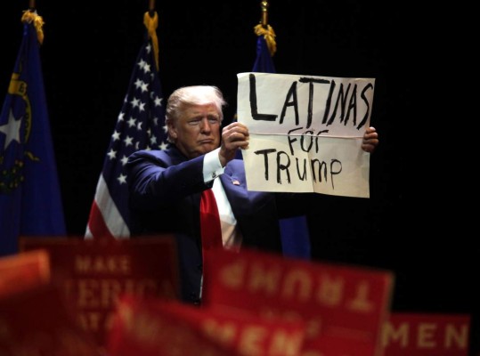 Republican presidential candidate Donald Trump holds up a sign during a campaign rally at the Venetian Hotel on October 30, 2016 in Las Vegas, Nevada. / AFP PHOTO / John GURZINSKI